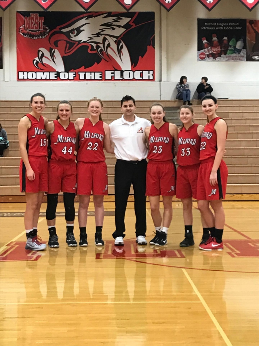 girls basketball team and coach on court